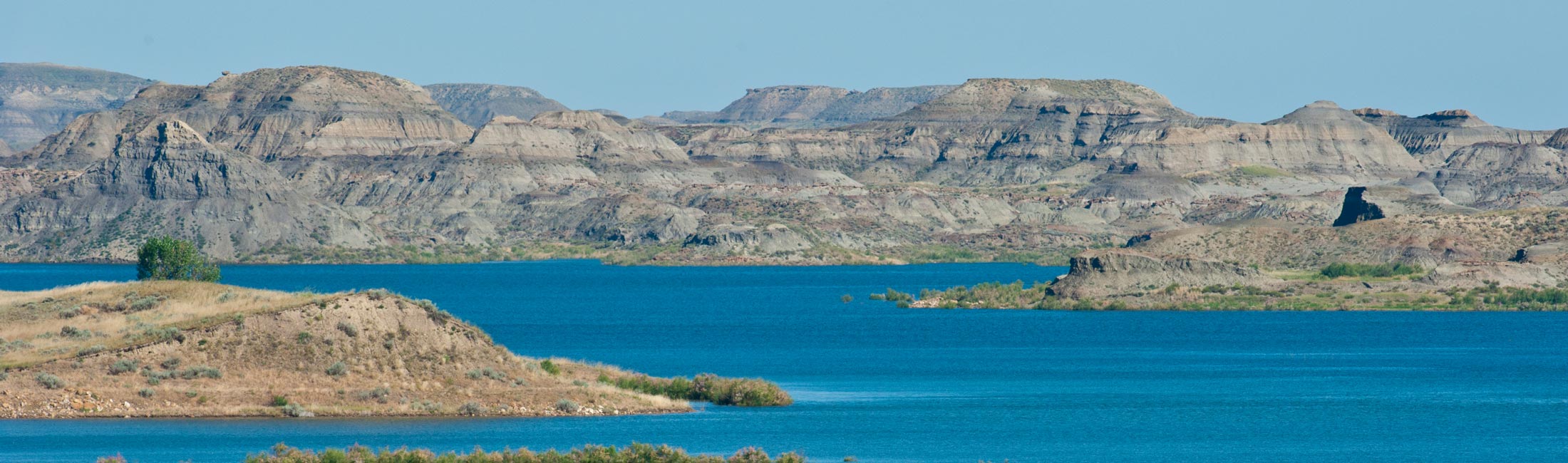 Missouri River meeting Fort Peck Lake with hills in background