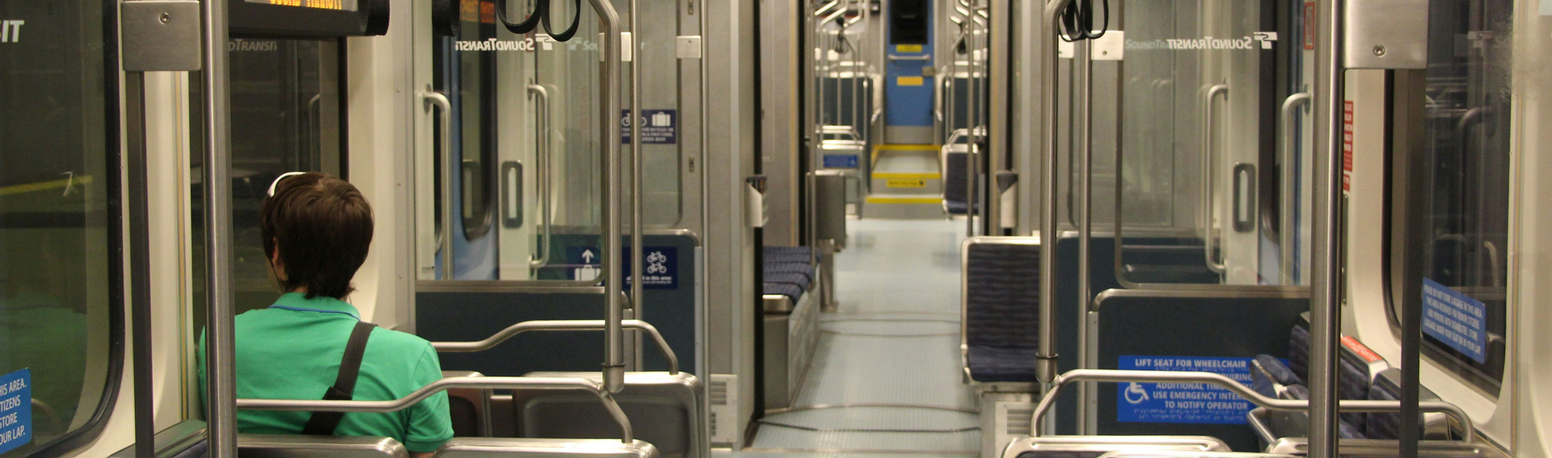Man seated looking out a window on public transportation.