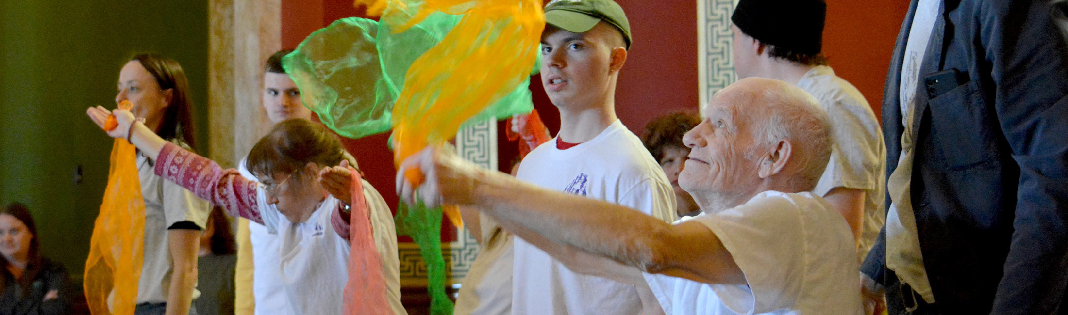 people playing with large translucent colored ribbons