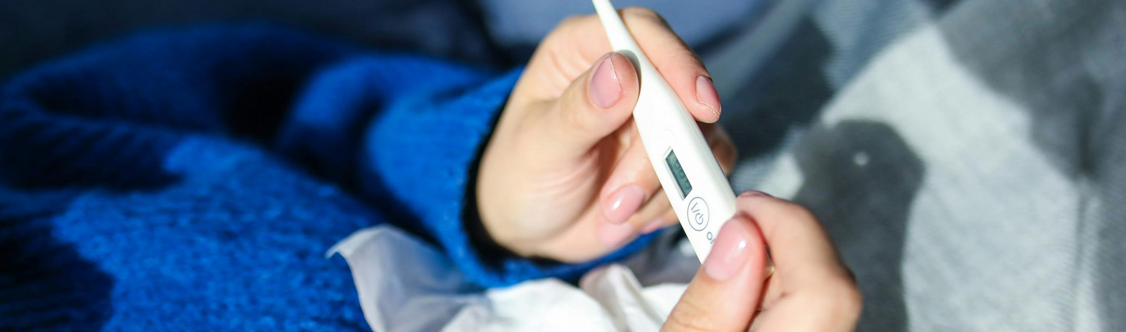 person holding electronic thermometer