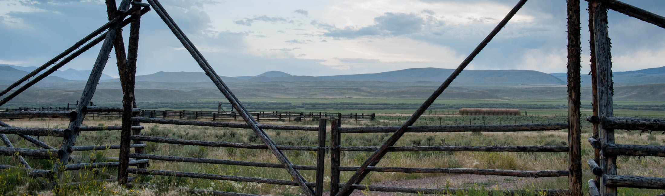 wooden fence and gate with mountains in background