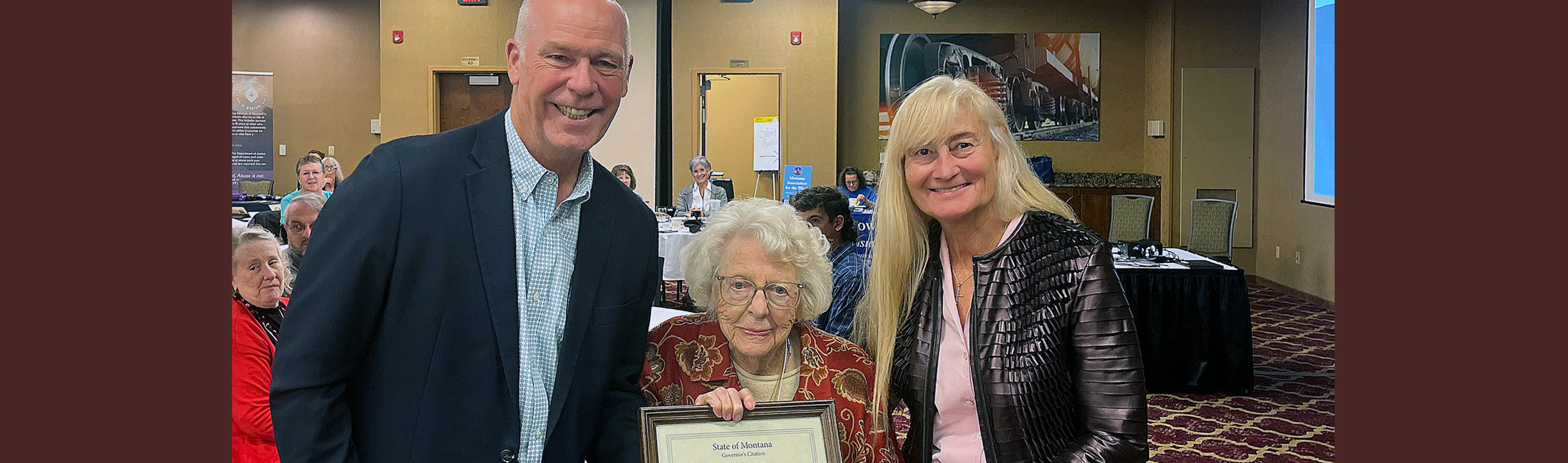 Greg Gianforte and wife Susan standing with Helen Janssen, born in Glendive, Montana holding Centenarian award