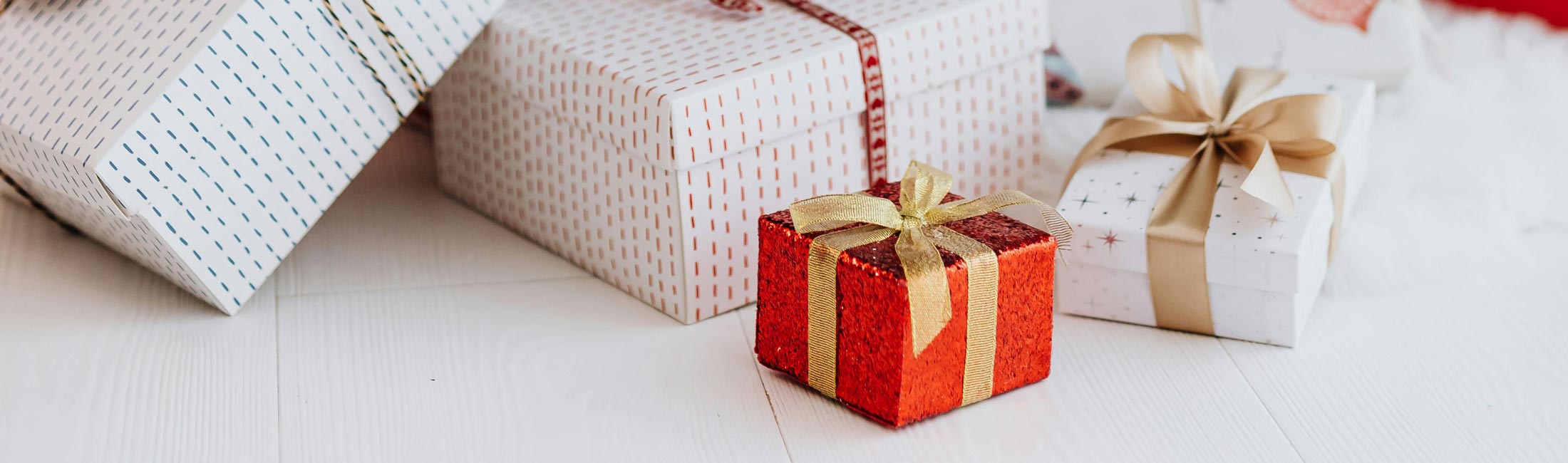 White and red presents wrapped in gold bows