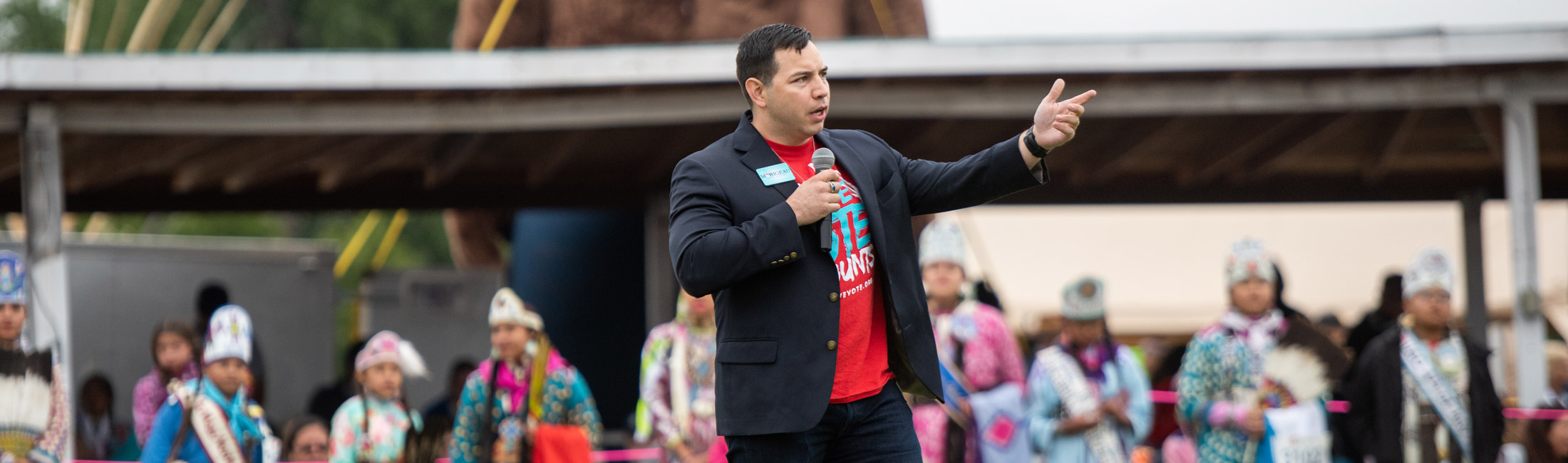 Man standing and speaking in front of crowd